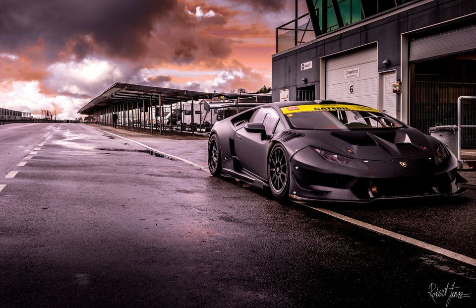 Mattsvart Lamborghini Huracán i depån under rosa kvällshimmel