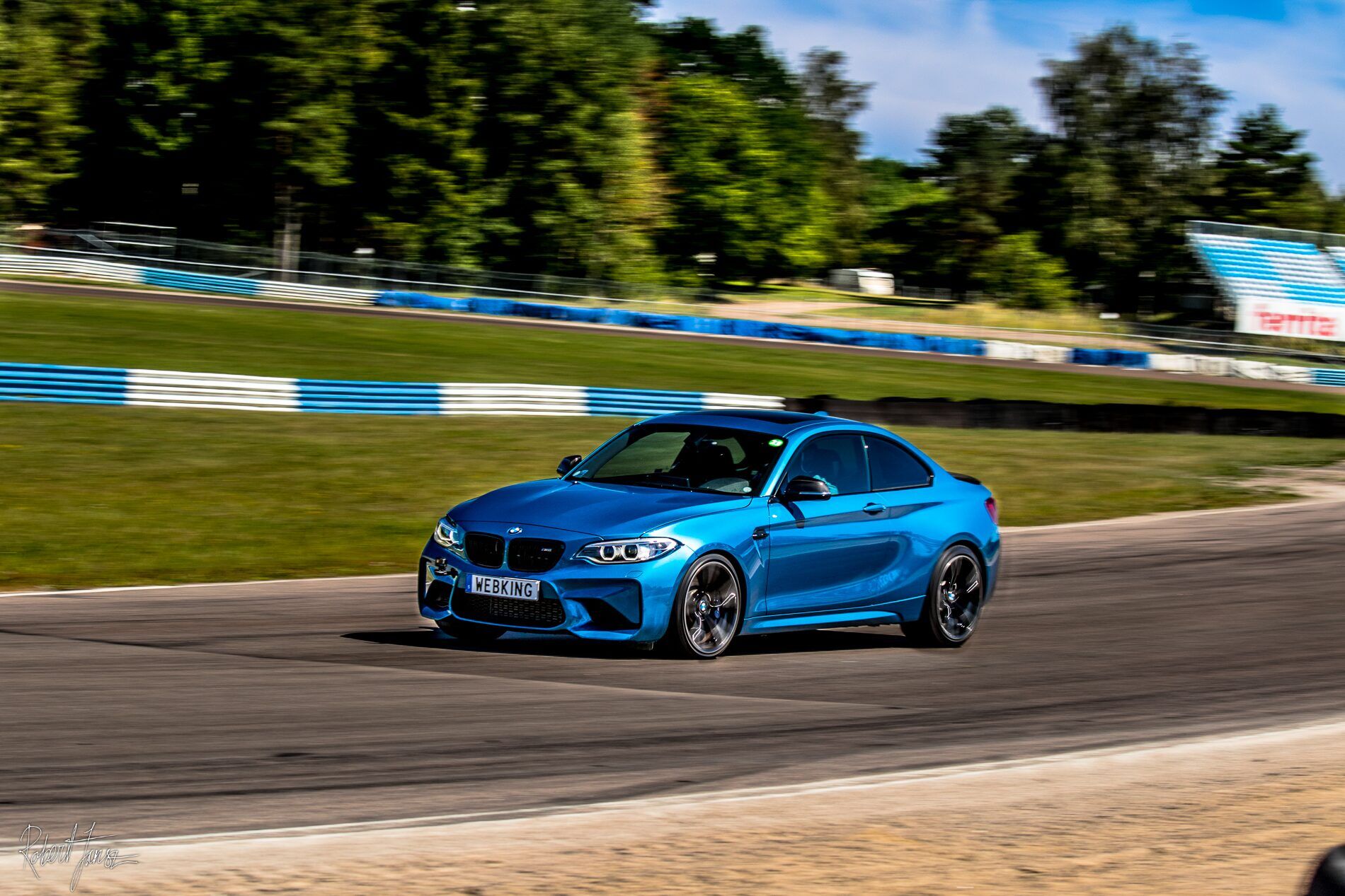 Blå BMW M2 i full fart genom en kurva på Mantorp Park