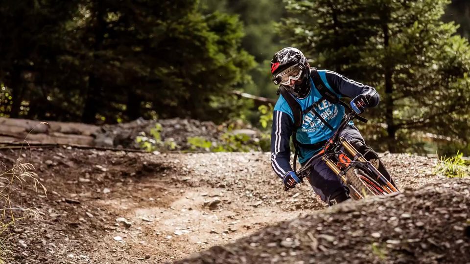 Cyklist i en doserad kurva i skogen